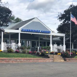 A park building entrance with an American flag and landscaped flowers.