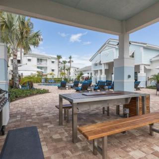 Outdoor seating area in a modern apartment complex with palm trees.