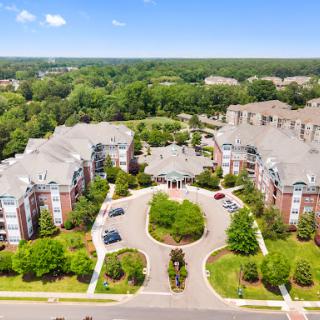 An aerial view of a well-maintained apartment complex surrounded by lush greenery.