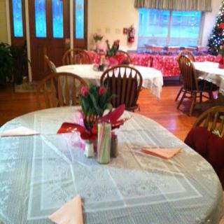 A cozy dining area decorated for the holiday season, featuring elegantly set tables and festive decor.