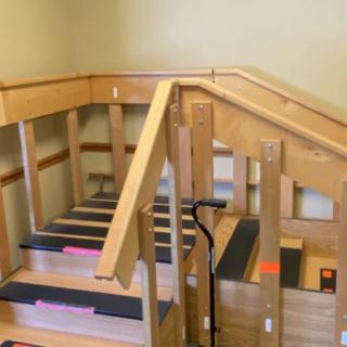 A wooden indoor staircase used for physical therapy and rehabilitation exercises.
