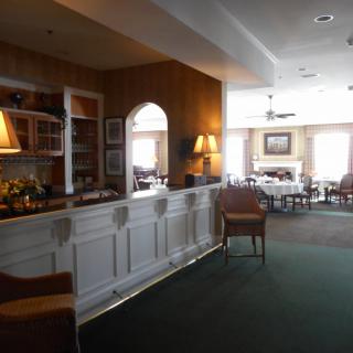 A cozy dining area with a bar and seating, featuring ambient lighting.