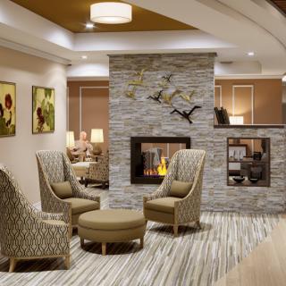 A cozy and modern lobby area featuring comfortable seating and a fireplace.