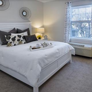 A modern and cozy bedroom with a large bed, soft lighting, and minimalistic decor.