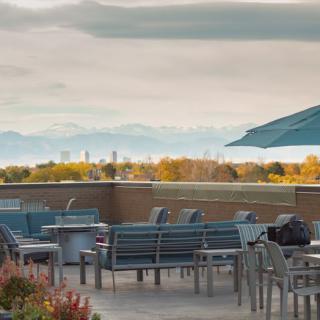 A scenic outdoor patio with seating and umbrellas, offering a picturesque view of the landscape and sky.