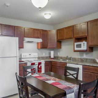 A cozy kitchen with wooden cabinets and a dining area.