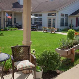 A tranquil courtyard with lush greenery and cozy outdoor seating.