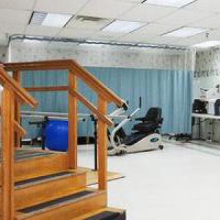 A rehabilitation room equipped with exercise equipment and therapy stairs.