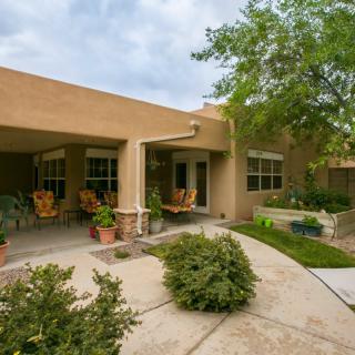 A cozy outdoor patio area with potted plants and comfortable seating.