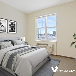 A minimalist bedroom with a neatly made bed and large window.