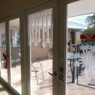 A bright patio view through sliding glass doors adorned with decorative decals.