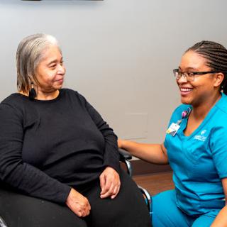 A nurse provides compassionate care and support to an elderly patient during a consultation.