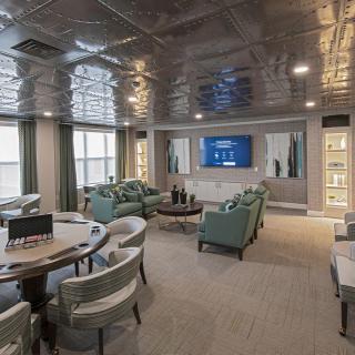 A modern lounge with stylish seating and a large TV, creating a comfortable and contemporary living space.
