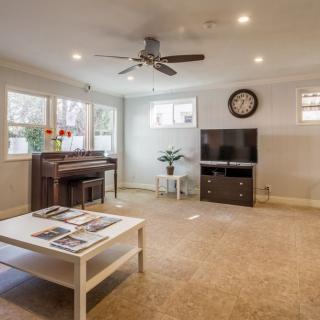 A cozy living room with a piano, TV, and coffee table.