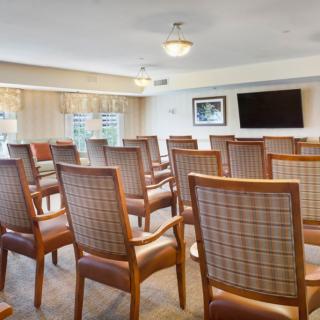 A well-arranged meeting room with chairs facing a television.