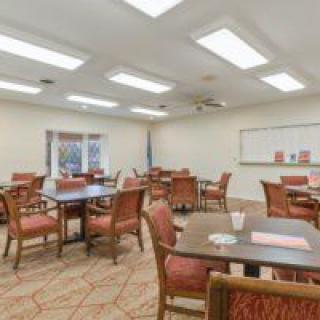 An interior view of an empty dining room with multiple tables and chairs arranged neatly.