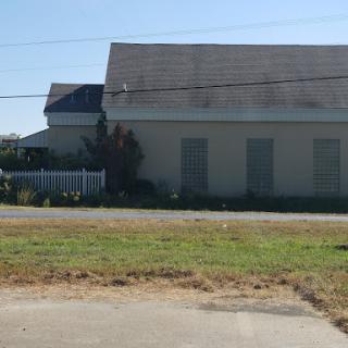 A view of a residential building with a grassy area in front.
