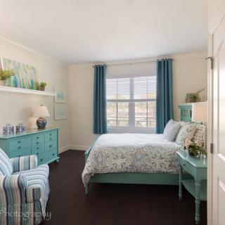 A cozy bedroom featuring turquoise decor and striped furniture.