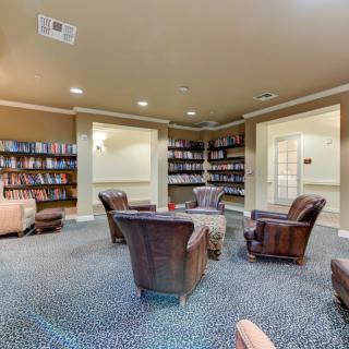A cozy library interior with armchairs and bookshelves.