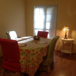 A cozy dining room with a floral tablecloth and a warm lamp.