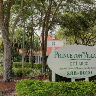 Sign for Princeton Village of Largo amidst lush greenery and trees.
