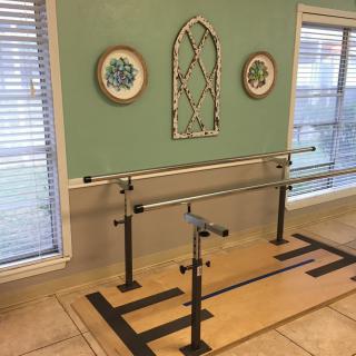 A cozy home workout space featuring a ballet barre and decorative wall art.