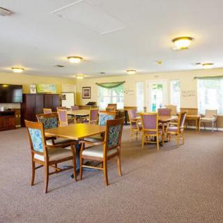 A spacious and bright dining room with multiple tables and chairs arranged neatly.