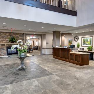 Modern hotel lobby with a reception desk and seating area.