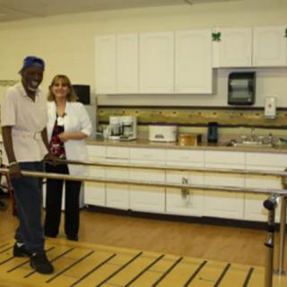 A healthcare professional assisting a patient in a rehabilitation facility.