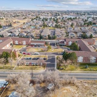 Aerial view of suburban residential area with multiple buildings and surrounding roads.