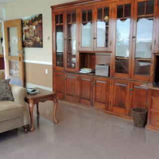 A cozy living room featuring a comfortable sofa and a large wooden cabinet with shelves.