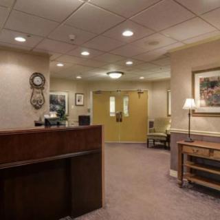 A reception area with a desk, seating, and artwork on the walls.