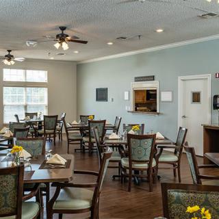A neatly arranged dining area with tables and chairs in a well-lit restaurant setting.