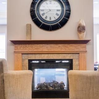 A cozy living room setting featuring a modern fireplace and a stylish wall clock.