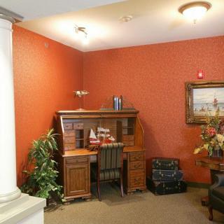 A cozy office corner with a wooden desk, chair, and decorative items.