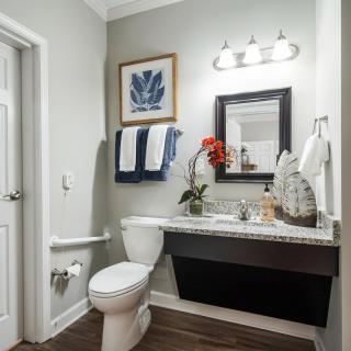 A modern bathroom with contemporary decor, featuring a sink, mirror, and neatly arranged towels.