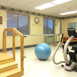A rehabilitation therapy room equipped with exercise equipment and an exercise ball.