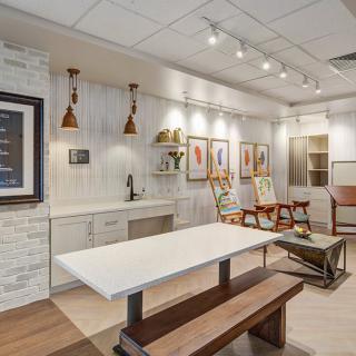 A modern interior design featuring a kitchen area with wood accents, stylish lighting, and framed artwork.