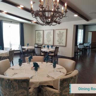 A beautifully decorated dining room with a chandelier and round tables.