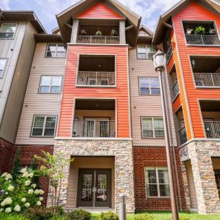 A modern apartment building with a mix of stone and siding exteriors.