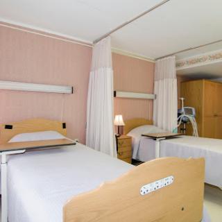 A view of a hospital patient room featuring multiple beds and a calming interior.