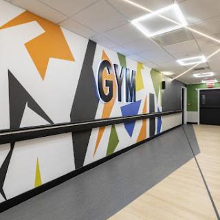 A vibrant gym interior featuring dynamic wall art and a sleek design.