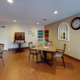A cozy game room with a table, chairs, and wall decorations.