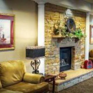 A cozy living room featuring a stone fireplace surrounded by elegant decor and comfortable seating.