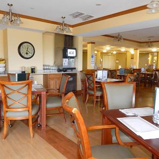 A cozy restaurant dining area with wooden furniture and ceiling fans.