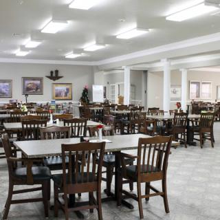 An empty dining area with rows of wooden tables and chairs.