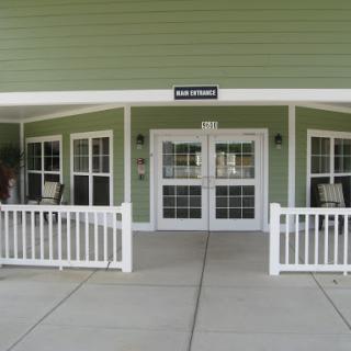 A welcoming entrance to a building with green walls and large windows.