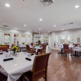 A cozy restaurant dining area with elegantly set tables and comfortable seating.