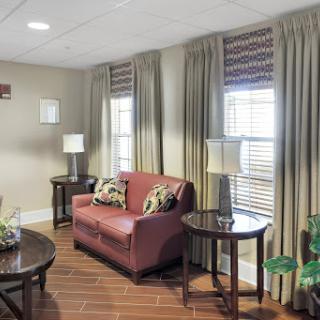 A cozy living room featuring a comfortable sofa, stylish lamps, and elegant curtains.