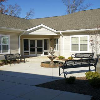 A peaceful residential courtyard with benches and a central fountain.